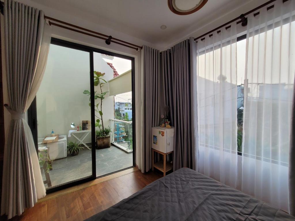 Cái RăngMIHA Villa的卧室设有大型滑动玻璃门和阳台