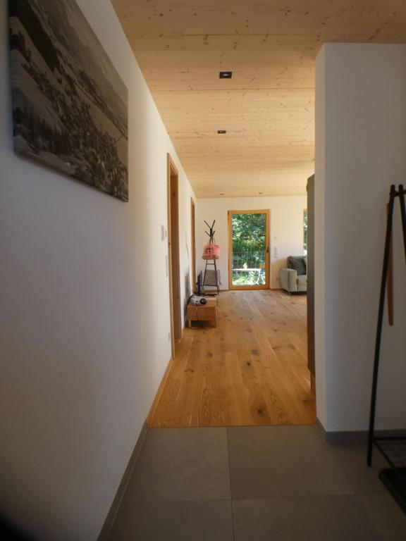 上施陶芬Stylische Fewo in Bestlage in neugebautem Holzhaus mit Oberstaufen Plus的一间拥有白色墙壁和木地板的走廊