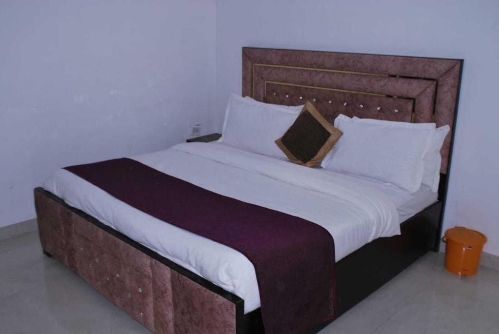 TājganjOYO Flagship 81442 Grey House Home Stay的一间卧室配有一张大床和木制床头板