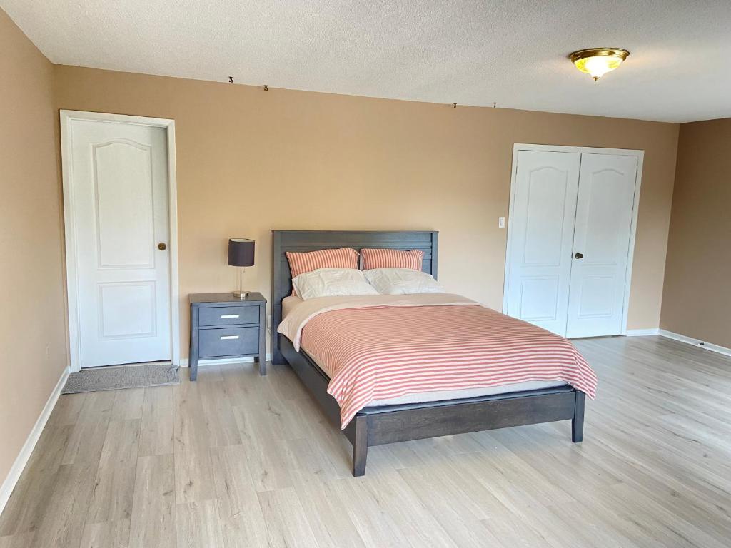 多伦多41 Huntsmill Blvd的一间卧室配有一张带床头柜的床和一张四柱床。