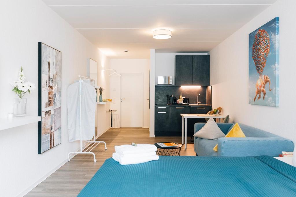 比勒费尔德Stadt-Appartement am Nordpark的一间带蓝色沙发的客厅和一间厨房