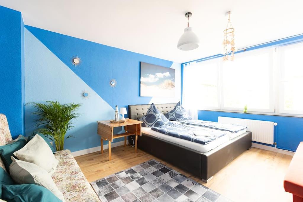 杜伊斯堡- Sea Apartment Duisburg Center & Parking spaces & Kingsize Bett - Central Station Hbf -的一间卧室设有一张床和蓝色的墙壁