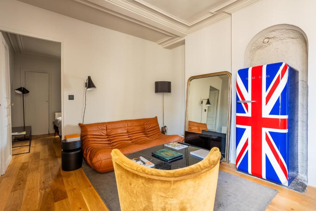 巴黎Bail Mobilite Luxe Le Marais的客厅配有沙发和墙上的旗帜