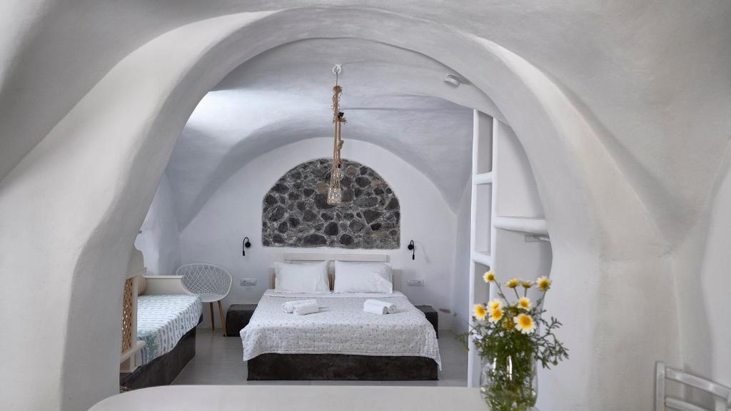 卡马利Mythos Traditional Stonehouse的一间白色客房内的床铺卧室