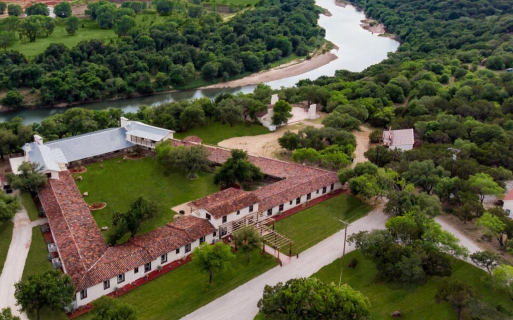 矿泉井城Rest Yourself River Ranch的享有建筑的空中景观,以河流为背景