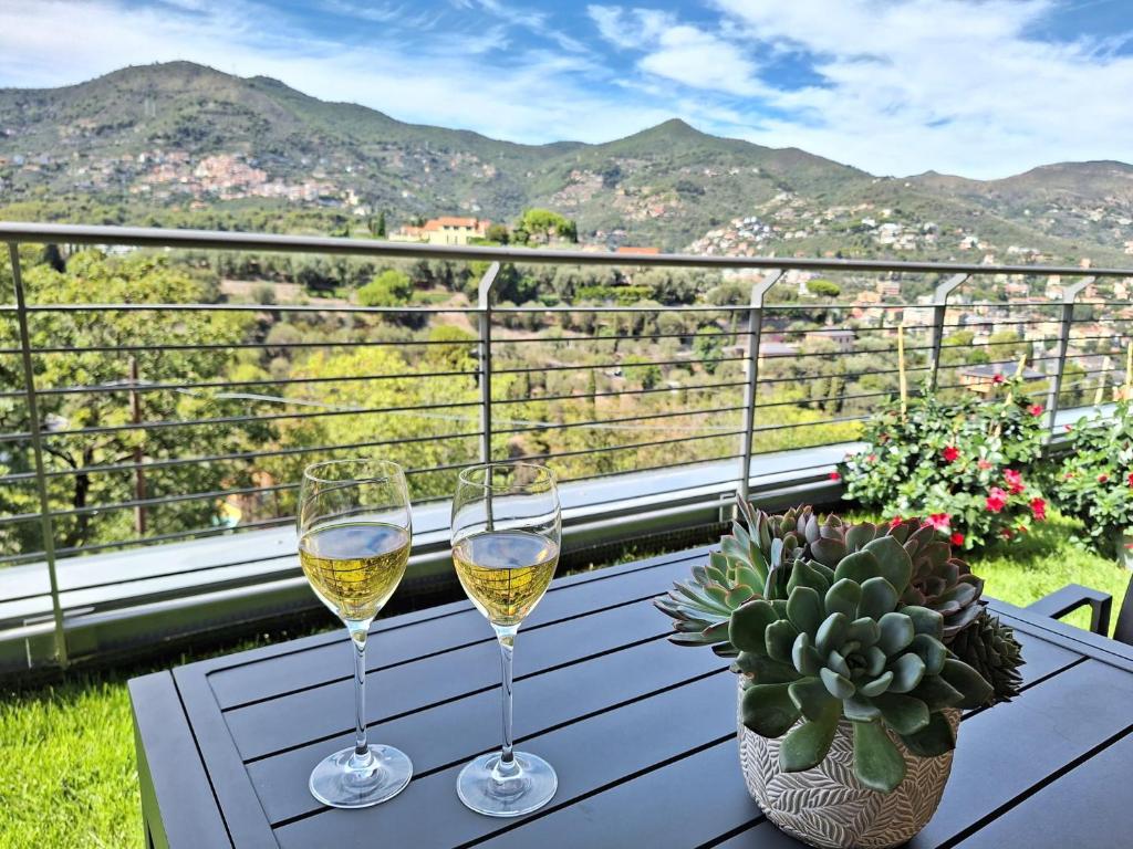 阿拉西奥Dolce Far Niente的阳台上的桌子上放着两杯白葡萄酒