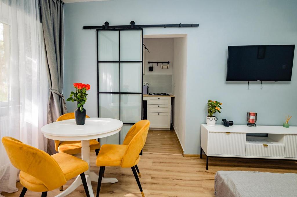 札勒乌Modern studio D-va N的客厅配有桌子和黄色椅子