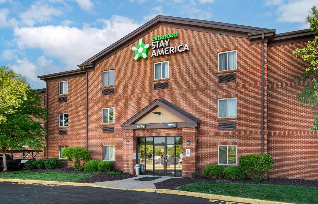 地球城Extended Stay America Select Suites - St Louis - Earth City的一座大型红砖建筑,上面有标志