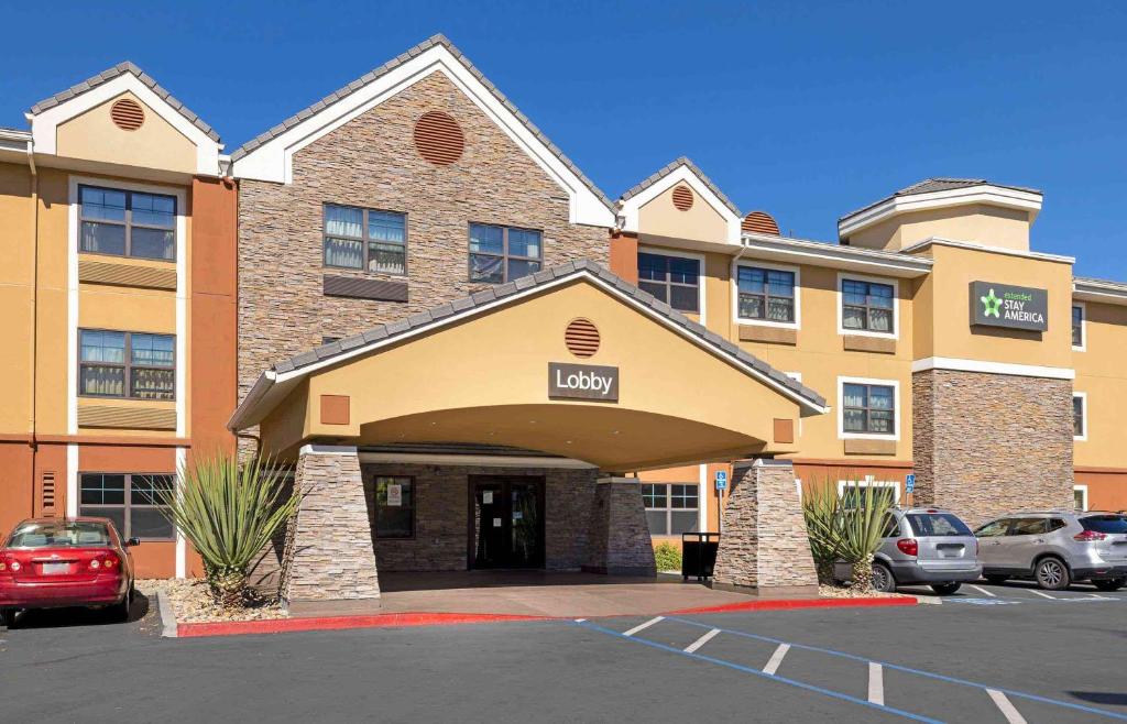 卡尔斯巴德美国长住酒店 - 圣迭戈 - 卡尔斯巴德海滨村庄的停车场内有车辆的旅馆