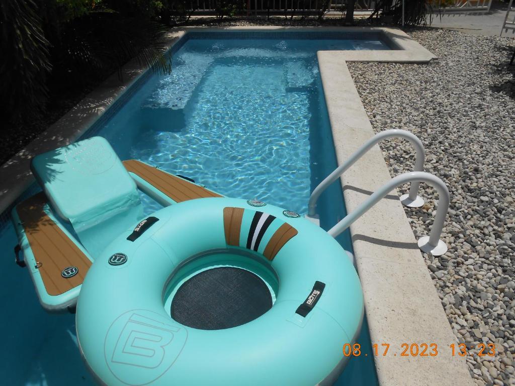 太子港Gustave Vacation House的游泳池里设有木筏和椅子