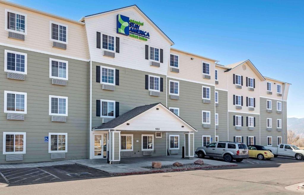 科罗拉多斯普林斯Extended Stay America Select Suites - Colorado Springs - Airport的门前有车辆停放的酒店