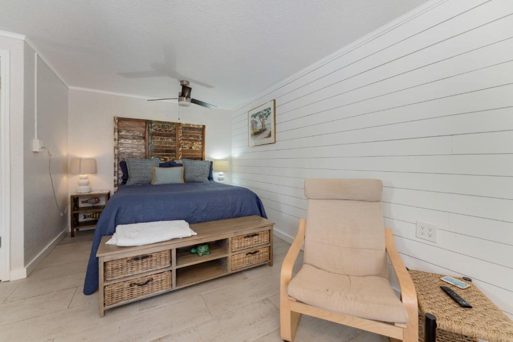 布雷登顿海滩Tides Inn on the Bay Vacation Homes的一间卧室配有一张床和一把椅子