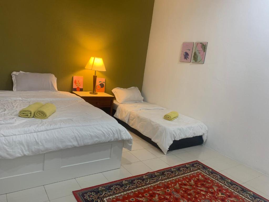 珍南海滩Rerama Room Stay Langkawi的一间卧室配有两张床和一张带台灯的桌子