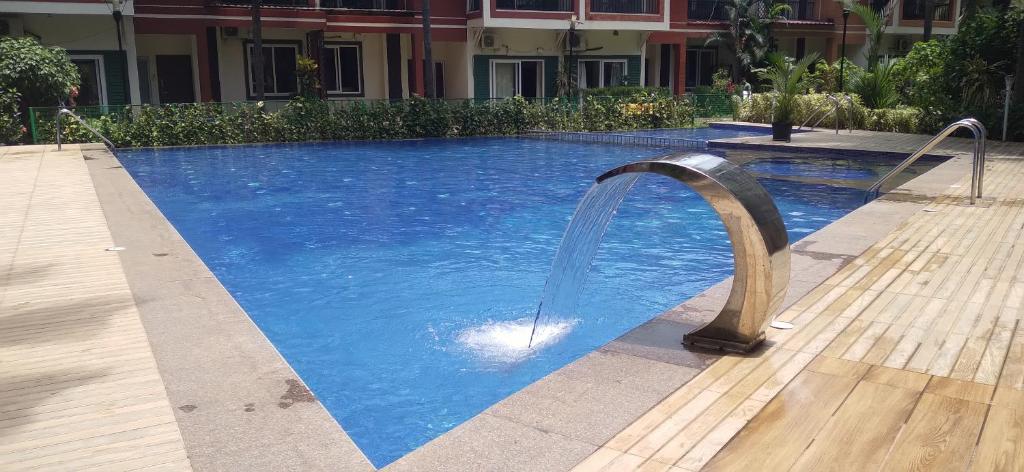 卡兰古特Luxurious Spacious 2 BHK With Pool Wi-Fi Cooking Gas Gym的游泳池内设有一个喷泉