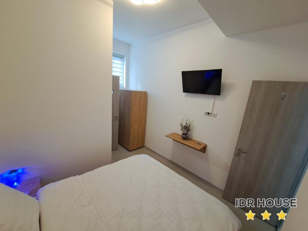 BuzăuIDR HOUSE的卧室配有一张床,墙上配有电视。