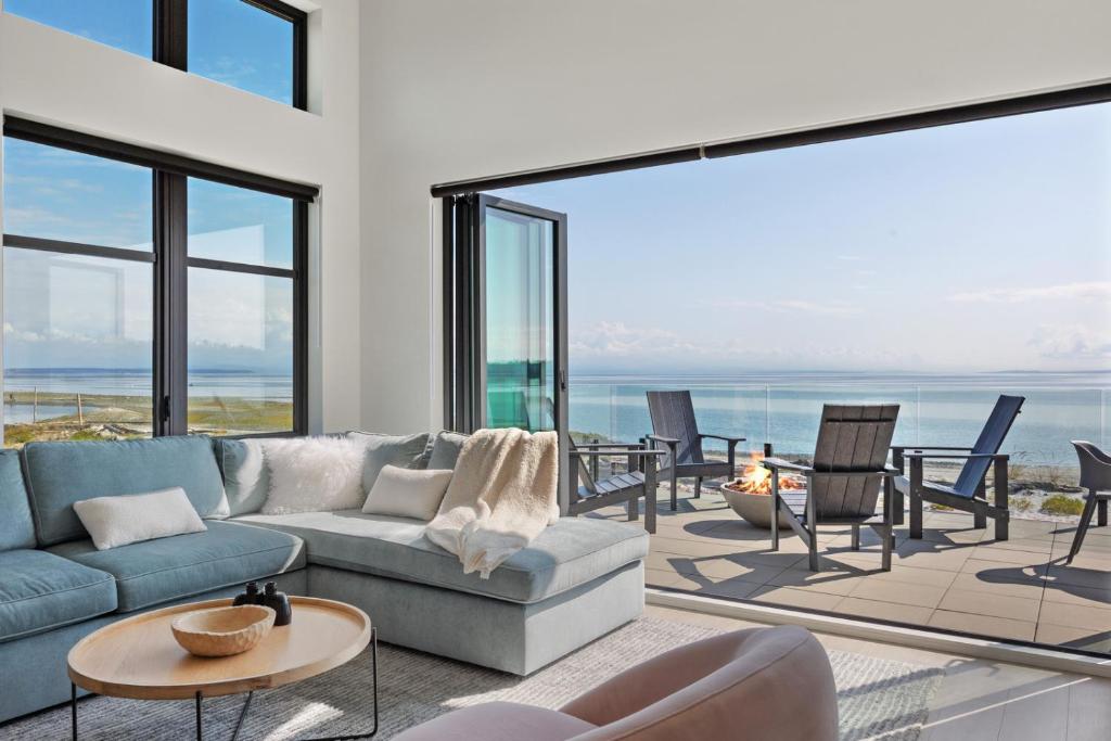 坎贝尔河Beachfront Luxury Suite #18 at THE BEACH HOUSE的客厅配有沙发、桌子和窗户