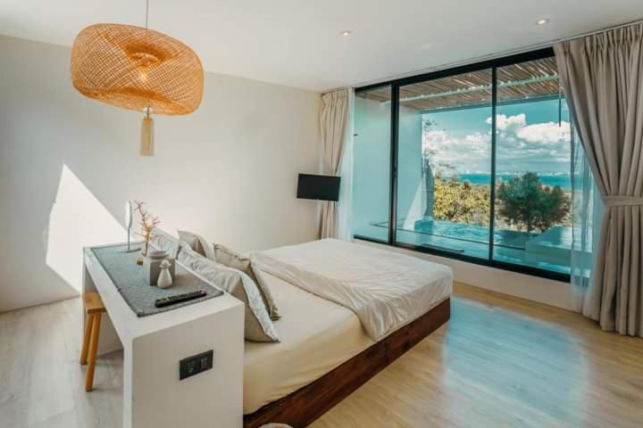格兰岛Myth Koh Larn resort bar and bistro的一间卧室设有一张床和一个大窗户
