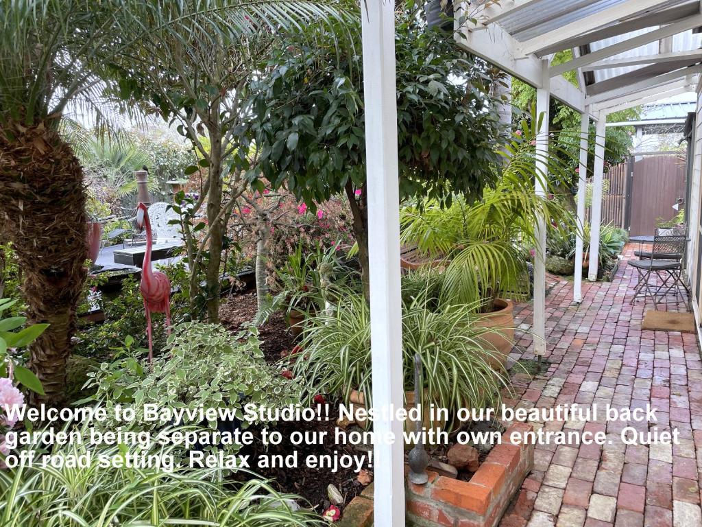 因沃洛什Bayview Studio的花园,种植了白色的凉棚和植物