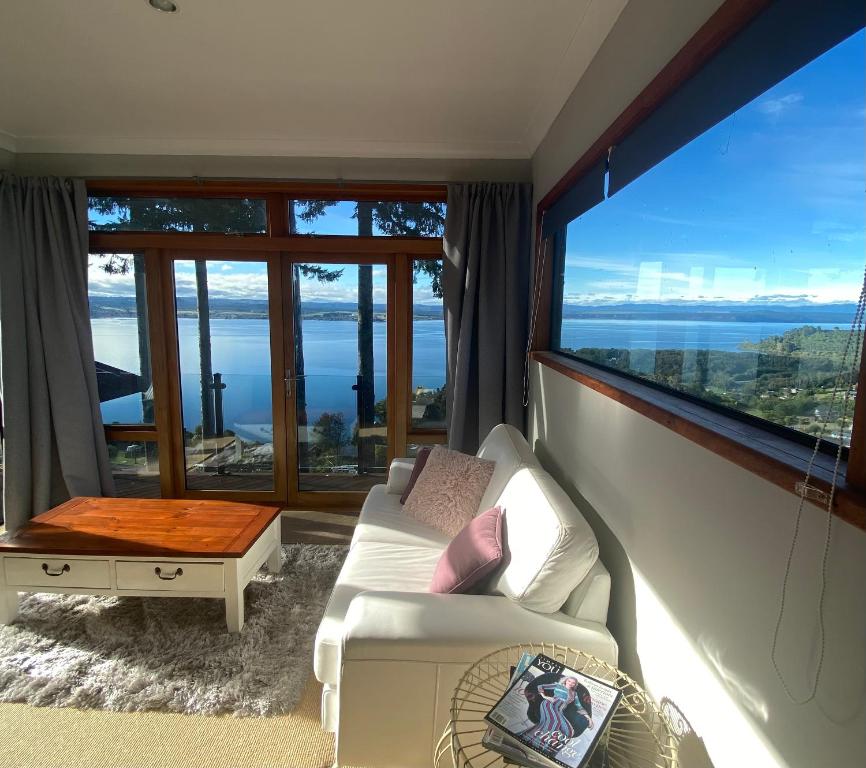 陶波The Nest - Relax & Unwind with Breathtaking Views over Lake Taupo的客厅配有白色沙发和大窗户