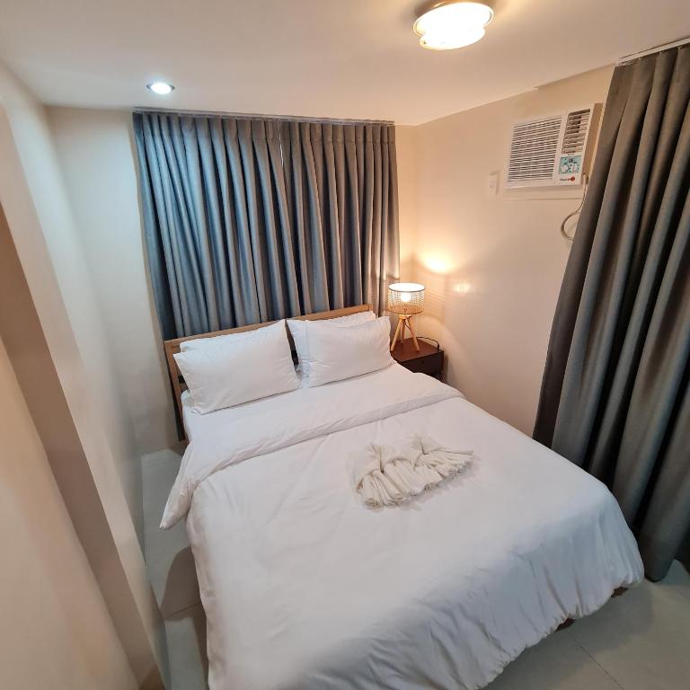 塔比拉兰Urban Homes Bohol的卧室配有白色的床和毛巾