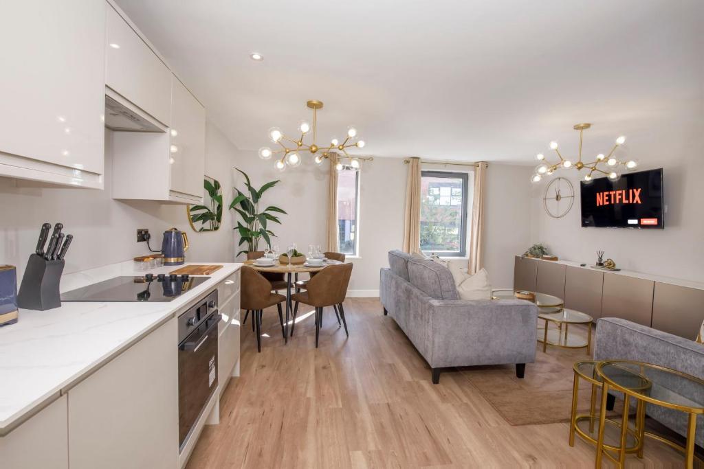 约克Crescent Court modern and luxurious Apartments York的厨房以及带桌椅的起居室。