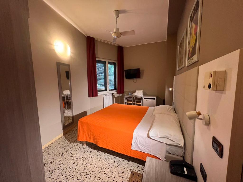 米兰帕尔马酒店的一间卧室配有一张带橙色毯子的床