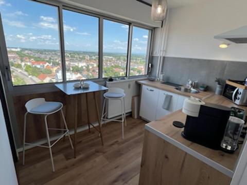 科尔马Superbe appartement Colmar avec vue et Jacuzzi的厨房设有2张凳子和1个带窗户的柜台。