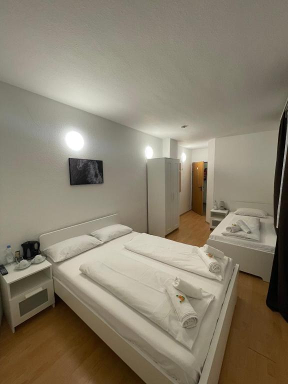 美因河畔法兰克福Hotel Starlight的一间卧室配有两张带白色床单的床