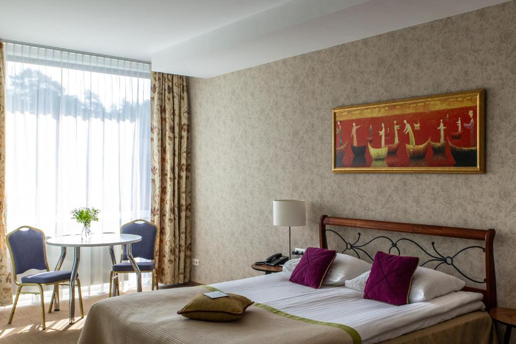 德鲁斯基宁凯MEDEA Apartments by UPA的一间卧室配有一张床和一张桌子及椅子