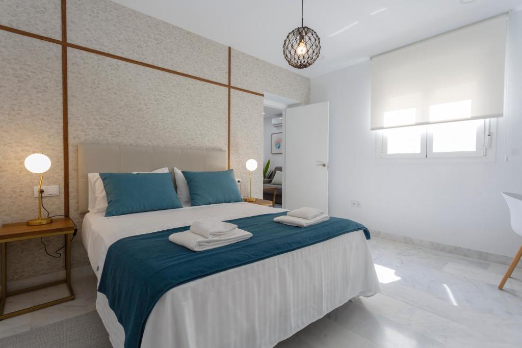 加的斯Apartamentos La BRUJULA by CadizRentals的卧室配有蓝色和白色的大床