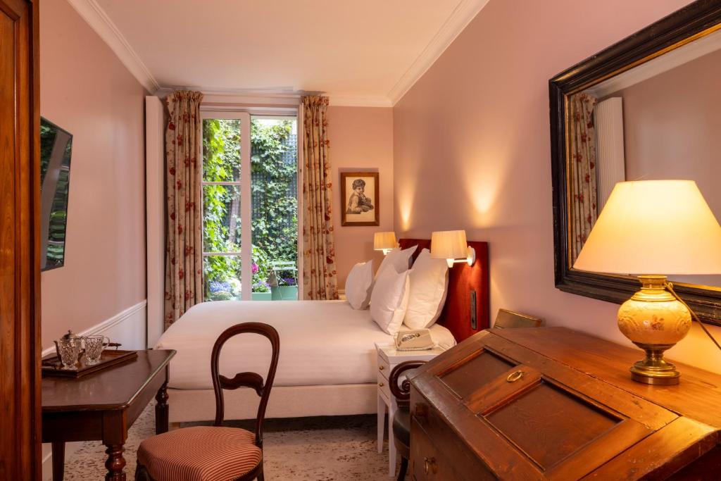 巴黎圣格力格奥尔酒店的一间卧室配有一张床和一张带台灯的书桌