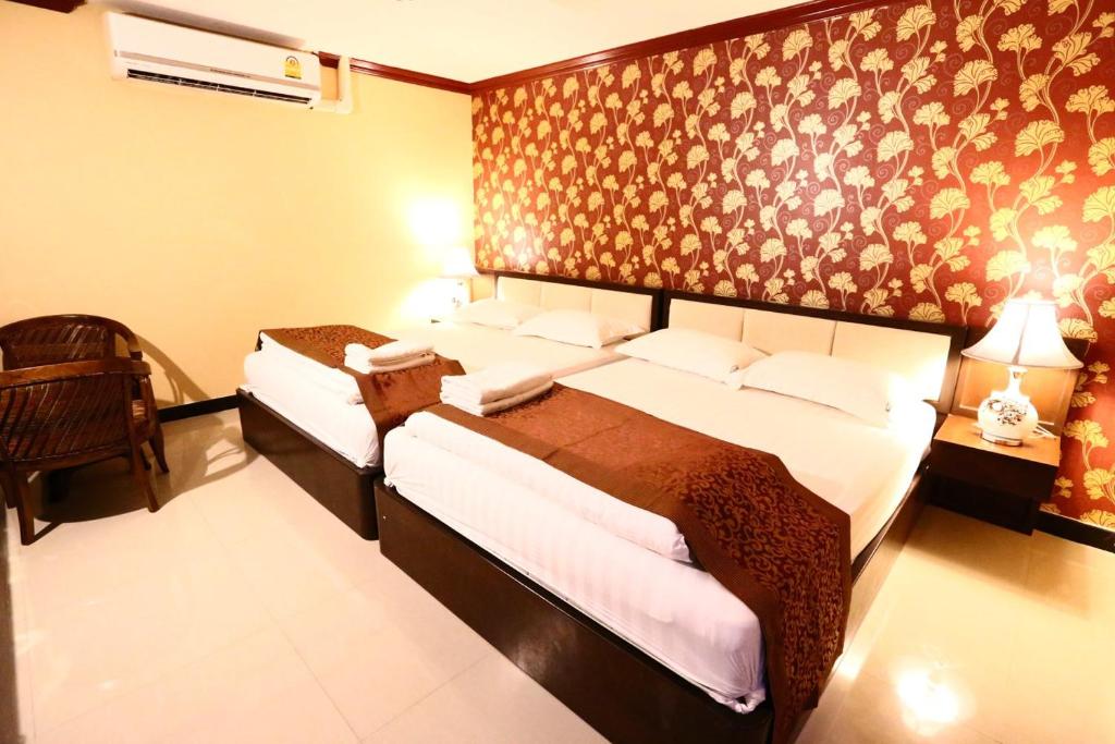芭堤雅市中心The Pattaya Sports Hub的一间卧室配有两张床和椅子