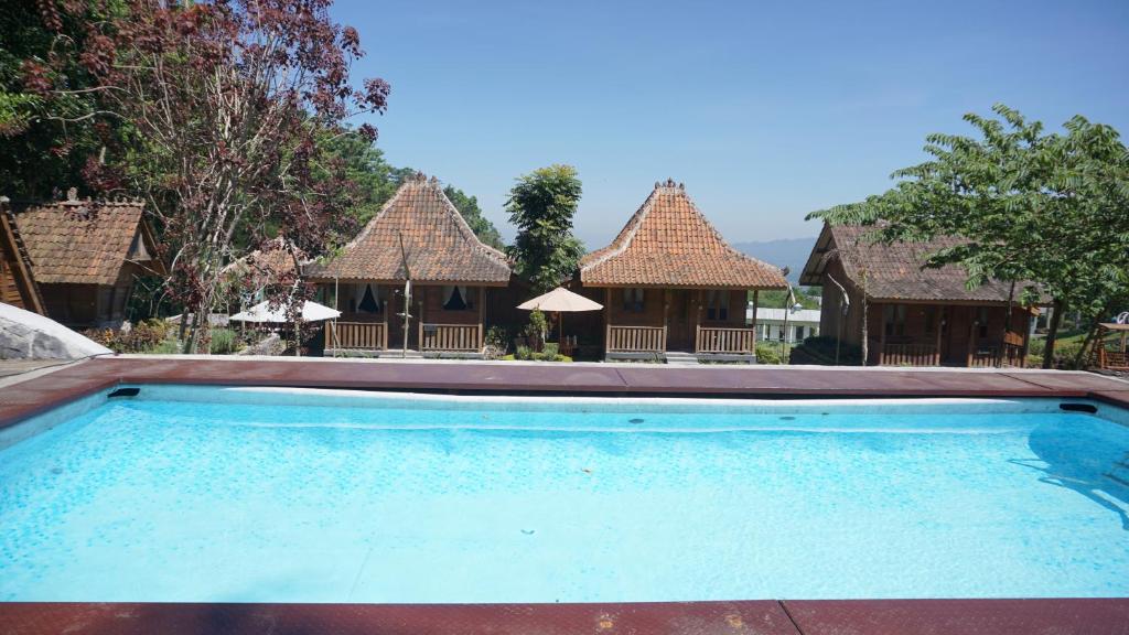 沃诺索博Le Desa Resort Syariah的一座空游泳池,位于一些建筑前面