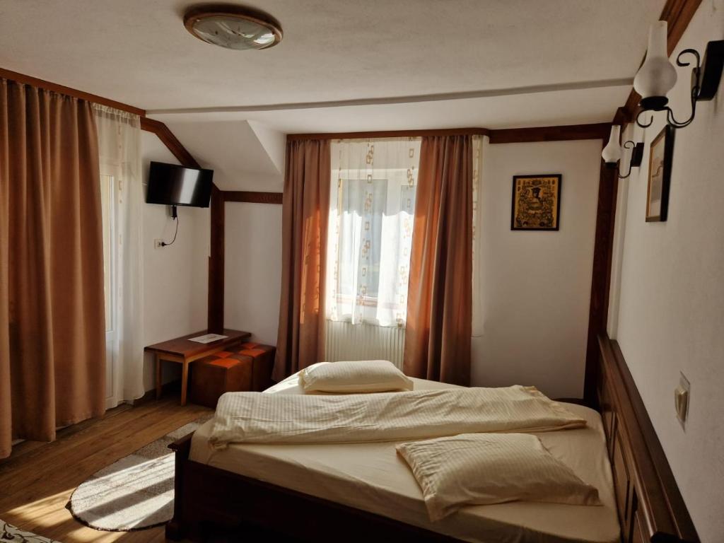 阿雷富Pensiunea Cota 1200 Piscul Negru的卧室在窗户前配有一张床