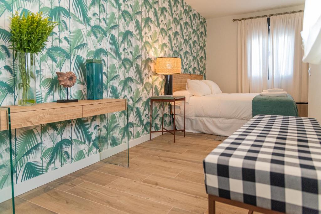 塞维利亚La Casa del Pintor Apartments的一间设有床铺和绿色及白色壁纸的客房