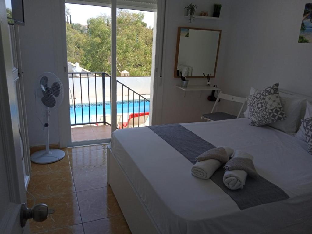 贝纳尔马德纳Tropical Suite的一间卧室设有一张床,享有游泳池的景色