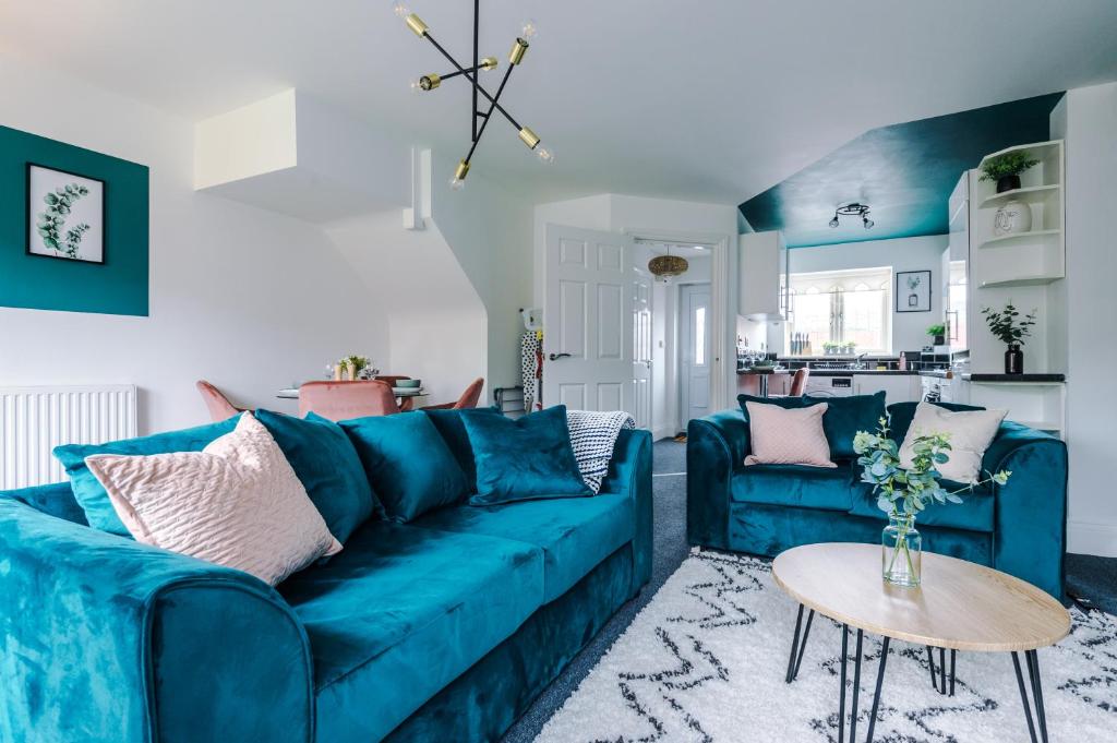 LitherlandLovely 4 Bed/ Monthly Discount/ Bottle的客厅配有一张蓝色的沙发,配有一张桌子