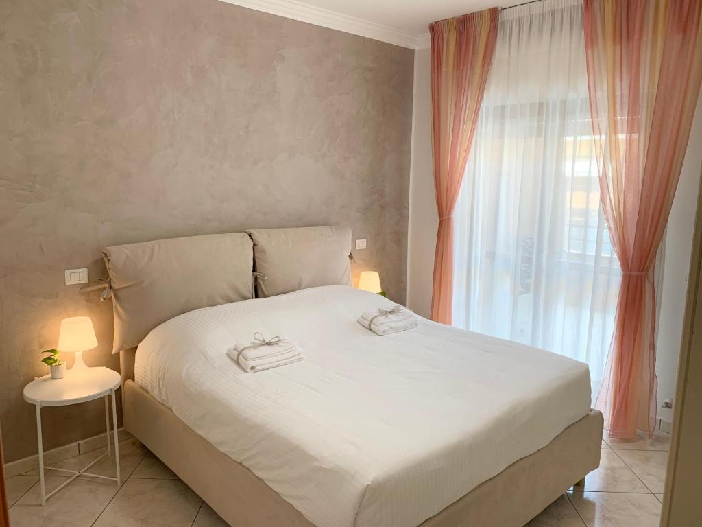 FolignanoLa Casetta的卧室配有白色的床和窗户。