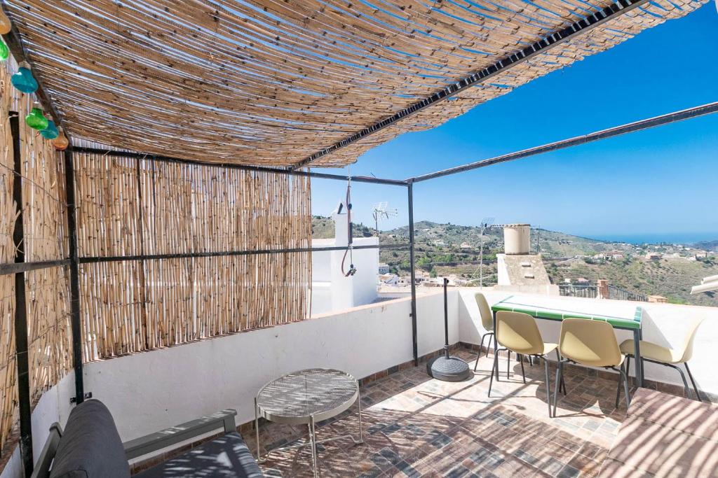 孔佩塔Casa Maria Cómpeta的设有一个配有桌椅并享有美景的阳台。
