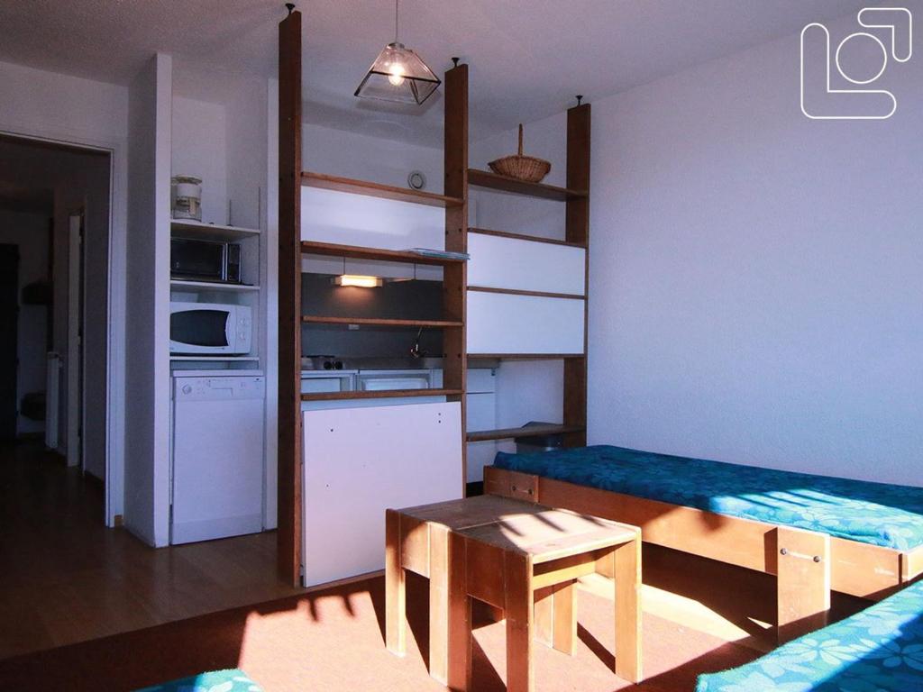 拉普德兹Appartement Huez, 1 pièce, 4 personnes - FR-1-405-65的一间小房间,设有厨房、一张桌子和一张沙发