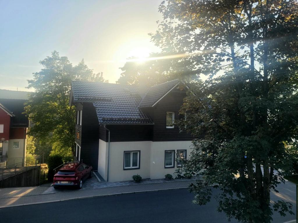 奥伯霍夫Pension & Ferienwohnung Oberhof 810 M的前面有一辆红色汽车的房屋