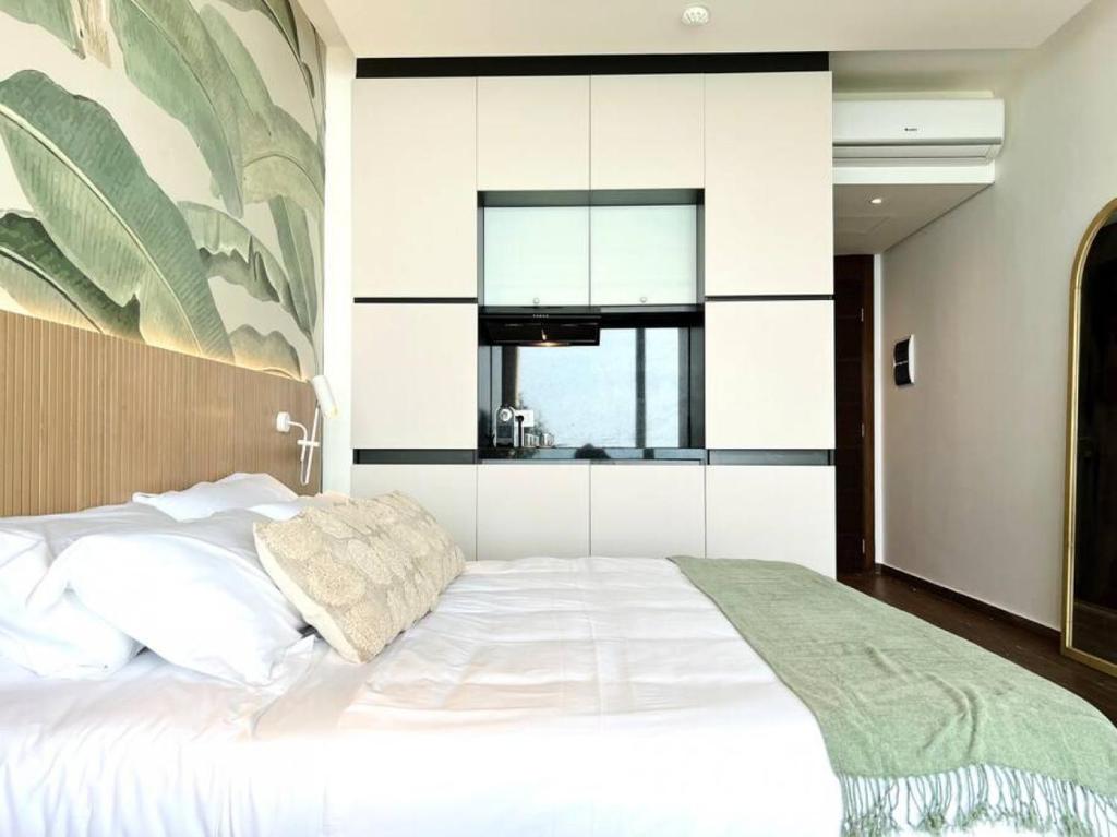 Banana Leaf Beachfront Exotic Room in Batroun的一间带白色大床的卧室和一间厨房