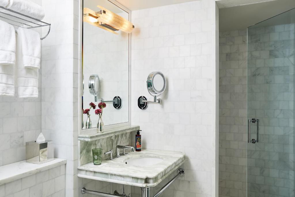 纽约The Fifth Avenue Hotel的白色的浴室设有水槽和镜子