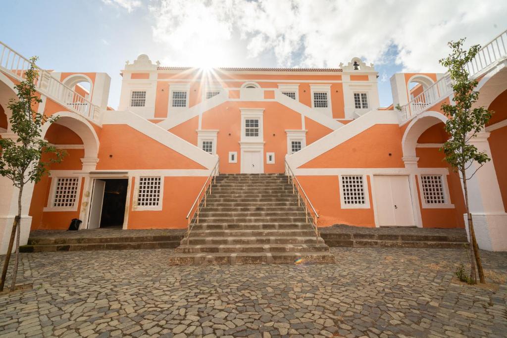 英雄港Palacio Santa Catarina Hotel的一座橙色的大建筑,前面设有楼梯