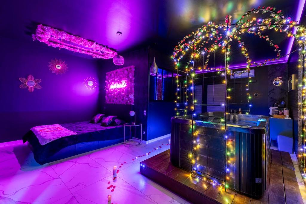 Le BreuilSweet SECRET'S JACUZZI的紫色卧室配有一张床和灯