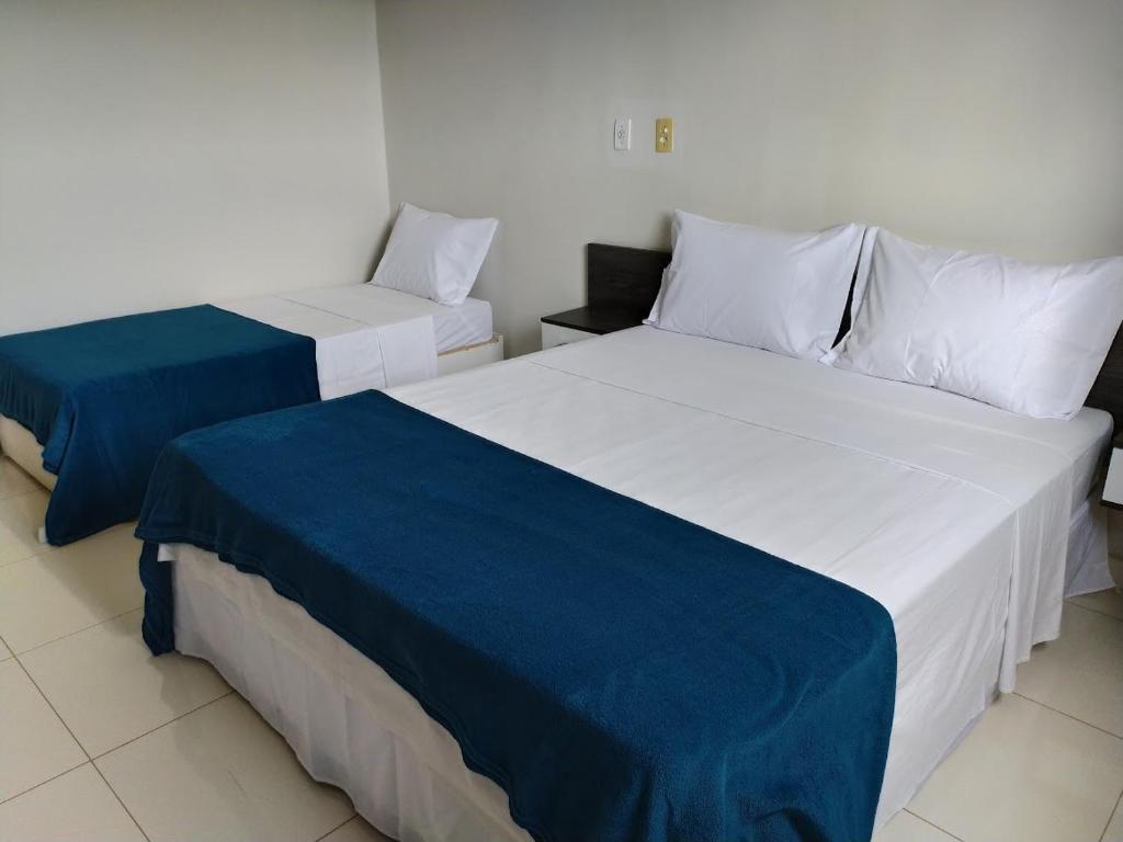 帕劳阿佩巴斯Maper Park Carajás的两张带蓝色和白色床单的床