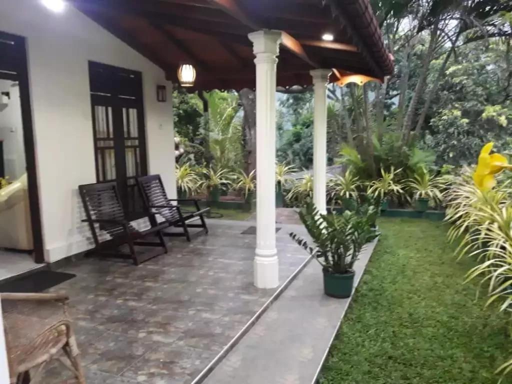 马特莱Doranagala Holiday Home的一个带椅子和植物的门廊
