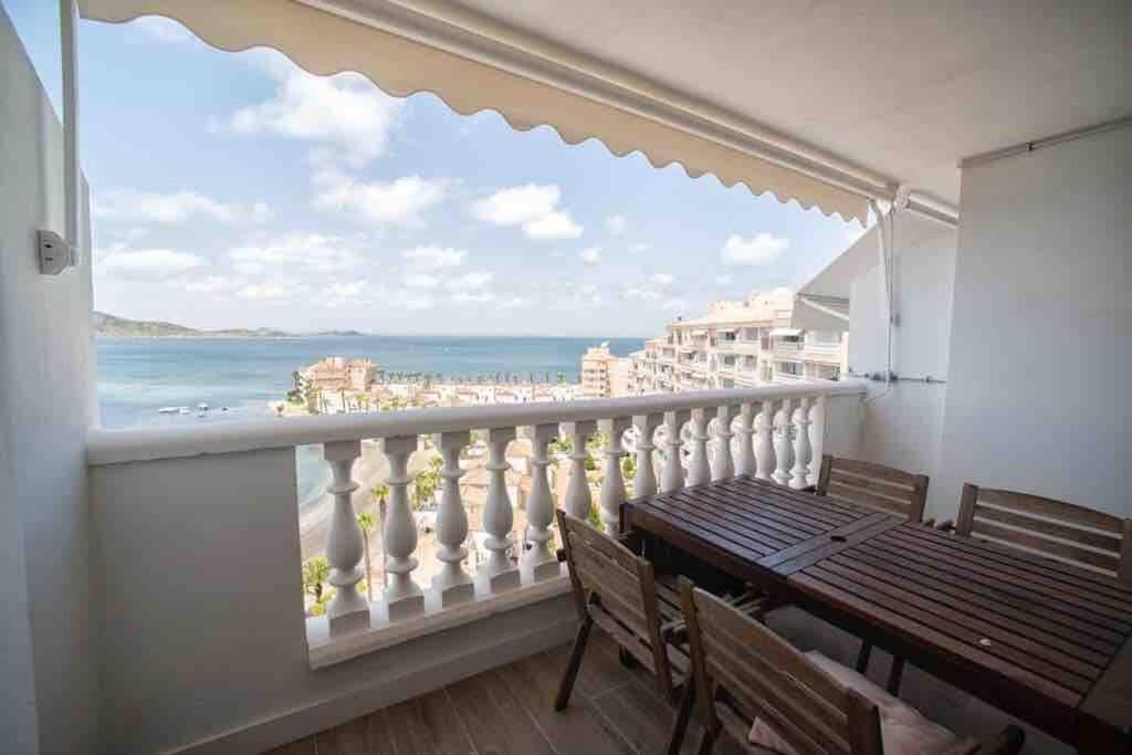 拉曼加戴尔马尔梅纳Renovated apartment in La Manga with great sunset的阳台设有木桌,享有海景。