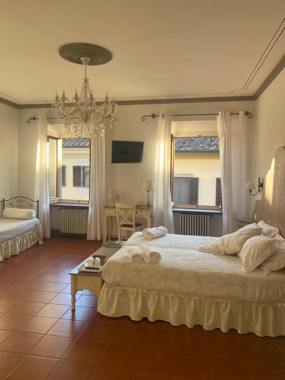 蒙特瓦尔基Palazzo Mari suite & rooms b&b的一间卧室配有一张大床和一个吊灯。