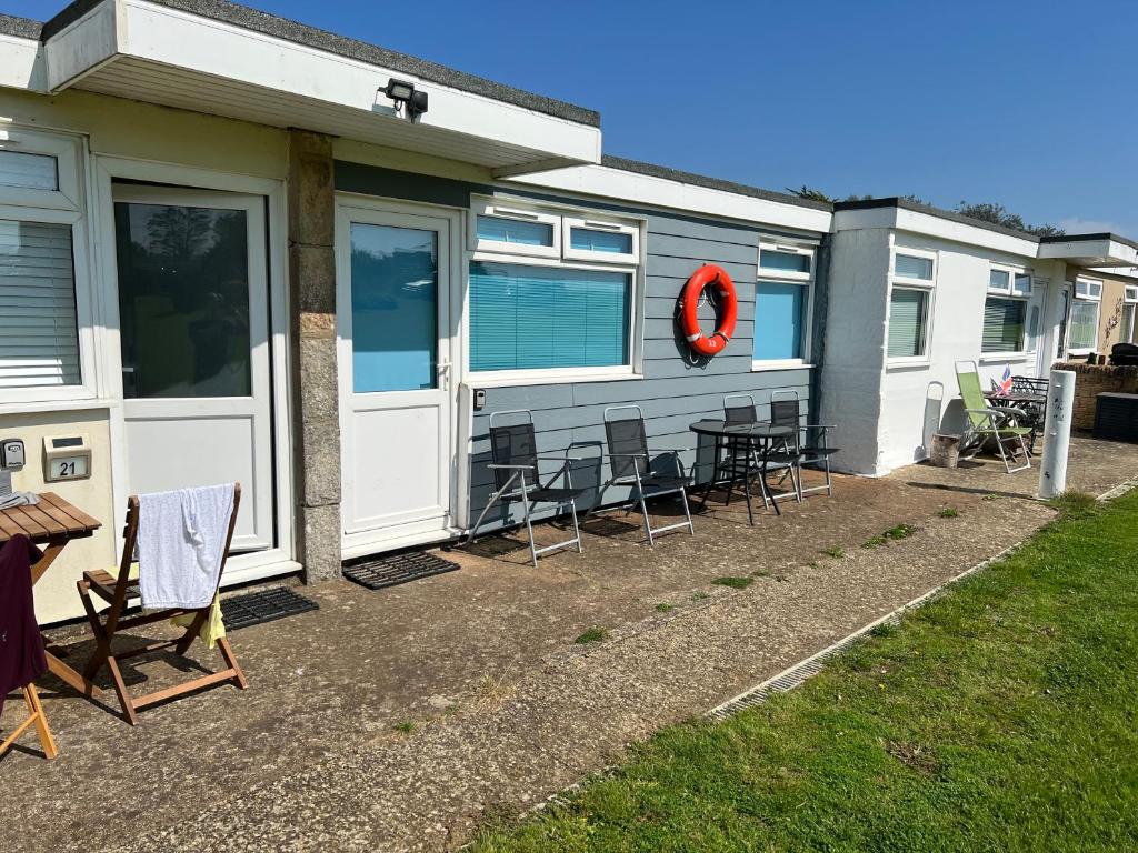 桑当2 Bedroom Chalet SB22, Sandown Bay, Isle of Wight, Dog Friendly的一辆拖车,车前配有椅子和桌子